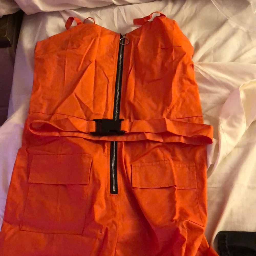 Orange jumpsuit with belt.